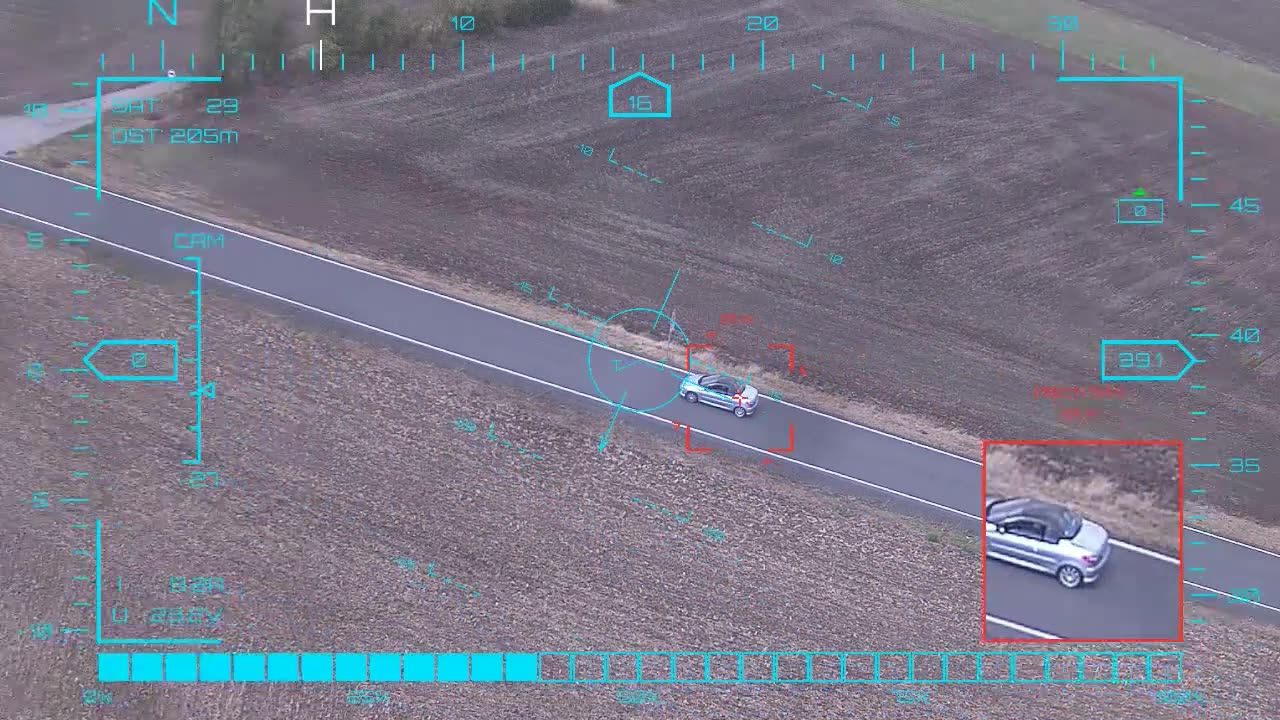 Silver car in a rolling frame — onboard AI target lock and real-time tracking from a UAV in strong crosswind, FPV goggles DVR
